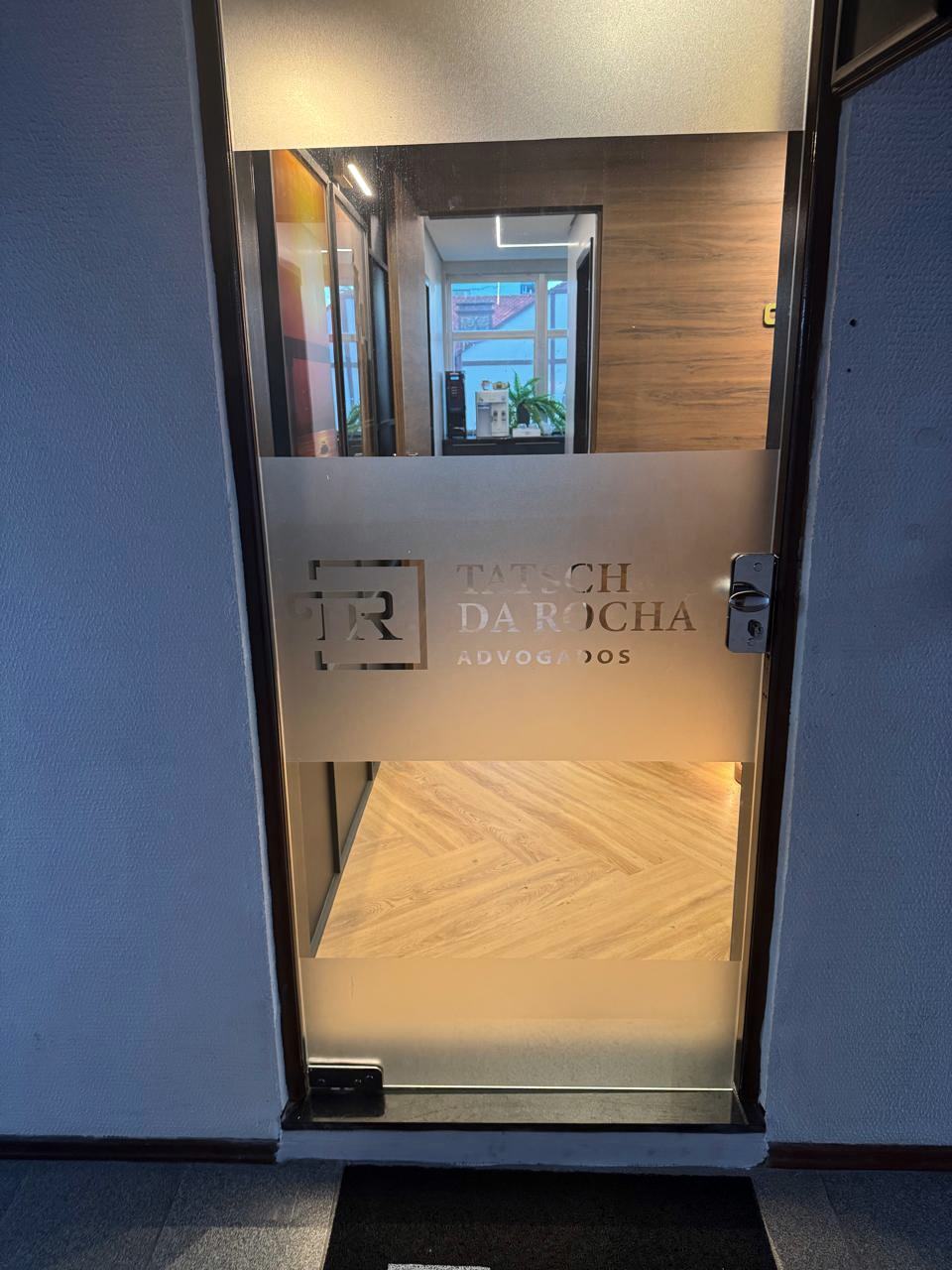 Porta de vidro do escritório com a logo da Tatsch da Rocha Advogados